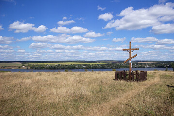 Ukraine, Vinnytsia region, Tokarivka village. Beautiful landscape, beautiful view of the river moat, meadow and Christian wooden cross