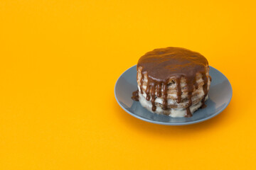 Chocolate cake with streams on a plate. Halloween concept, trick or treat. Orange background, handmade cooking, sweets with flows down. Brownies with cream. Copy space. Selective focus, blur.