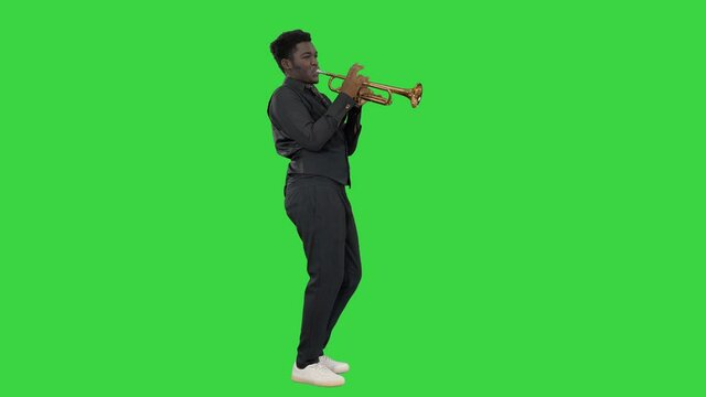 African american musician playing the trumpet expressively on a Green Screen, Chroma Key.
