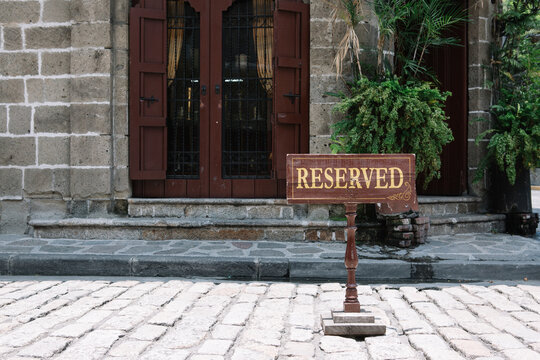 Reserved sign prominently displayed in front of a door entrance in an old town