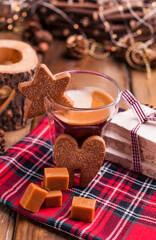 Espresso coffee, torrone, cookies and caramel on a wooden table. Christmas drink and festive decorations with garlands. Retro photo Happy New Year. High quality photo