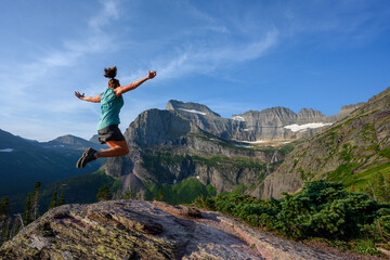 Naklejka na ściany i meble Woman Leaps With View of Grinnell Glacier