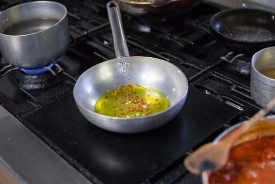 A pan with olive oil and garlic on a cooker