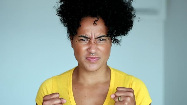 Upset black woman clenching fists, angry african person