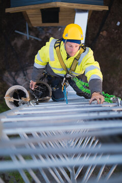 Working at heights, technician climbs up on a communications tower