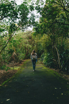 Woman walking alone in a green dark forest
