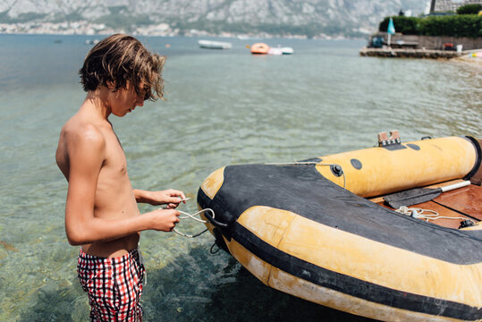 Young boy preparing for a ride in the rubber boat