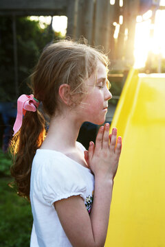 Girl Next To Slide With Hands In Prayer Position