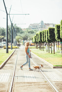 Woman Crossing the Street With Her Dog
