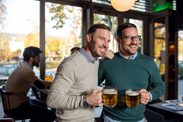 Friends in pub drinking beer and talking