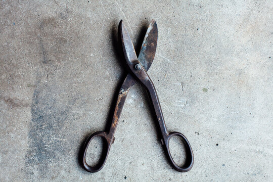 Tin nippers or wire cutters laying on concrete.