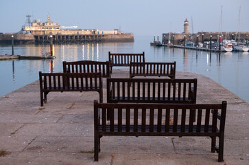 View of Ramsgate Royal Harbour, Kent UK,  taken in the early evening light with benches laid out of...