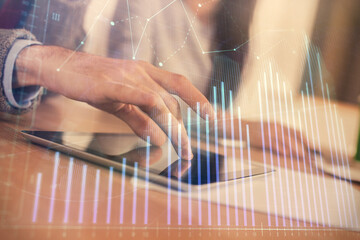 Double exposure of forex graph drawing and man and woman working together holding and using a mobile device. Trade concept.