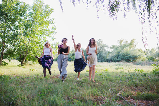 Happy female friends running in nature