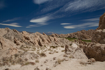 Geology. Arid desert landscape. Panorama view of the sharp rocky formations and sandstone under a blue sky. 