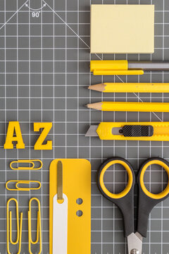 Yellow office utensils on a grey crafting mat