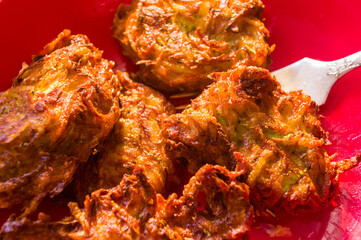 Fried vegetable fritters with zucchini, carrots, herbs, eggs, and cheese.