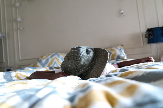 Young boy being bashful and laying on his bed