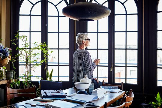 Senior Woman Having Coffee While Looking Through Window