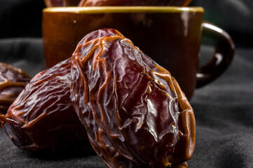 Big luxury dried date fruit on the dark surface, kurma ramadan kareem concept, close up.