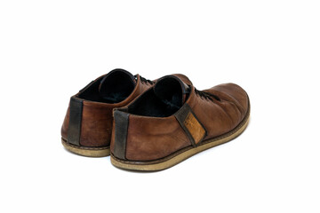Old dirty brown leather shoes on an isolated white background. Concept, second hand, hard work,...