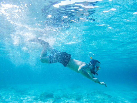 Young man diving in crystal clear waters