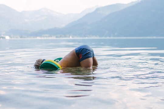 cute toddler diving in a lake with his butt above