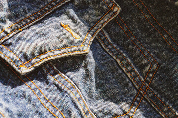 Naklejka premium blue denim background on the sides with seams of brown threads
