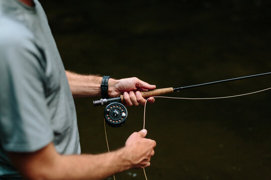 Close up of hands with fishing rod and line outdoors