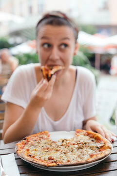 Young woman eating pizza