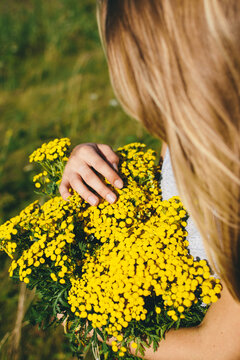 Woman holding big bouquet of wildflowers