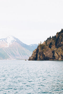 A Sheer Island Cliff Jutts Into The Ocean Waters Of Resurrection Bay Alaska