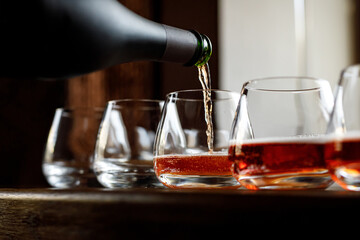 Waiter pouring wine into wineglass. Sommelier pours alcoholic drink.