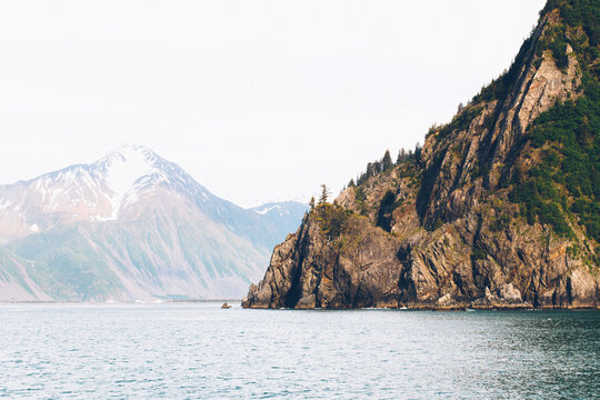 A Sheer Island Cliff Jutts Into The Ocean Waters Of Resurrection Bay Alaska