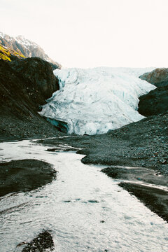 An Icy White Glacier Begets A Clear Cool Stream