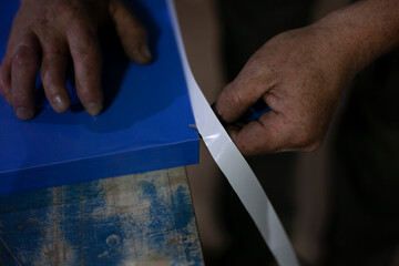 The self-adhesive advertising film is cut with a knife.