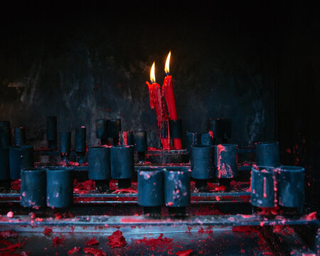 A couple of lighted red candles in a temple