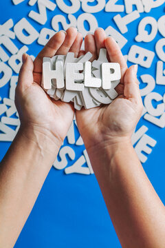 Hand Holding White Wooden Letter with a Help Messagge