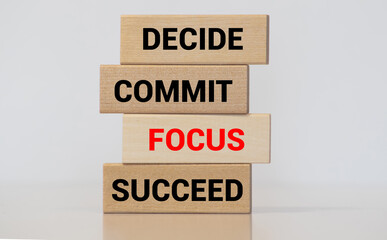 Motivational and inspirational quote Decide, commit, focus, succeed written on wooden blocks.