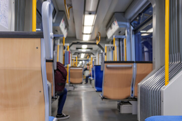 Interior view of a corridor inside passenger trains or light rail tram with blue fabric seats of...
