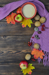 Warming cocoa in cold season, scarf, apples, autumn leaves, nuts. Concept decoration and celebration thanksgiving day
