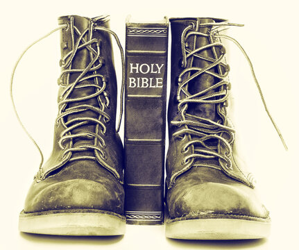 Bible and boots on gray background
