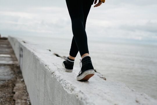Solitary woman walking on apier