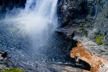 waterfall in the forest with logs