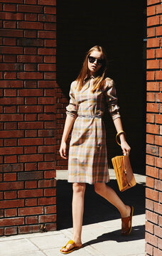 Blonde girl posing against brick walls