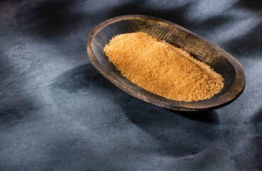 Saccharum officinarum - Organic brown sugar in the wooden bowl