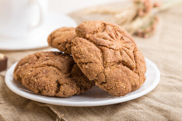 homemade oatmeal cookies with a cup of cocoa on a white wooden background. side view, selective focus.
