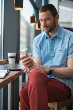 Man checks his phone at the caffee.