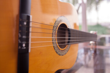 Obraz premium Yellow wooden acoustic guitar closeup. Bottom perspective.
