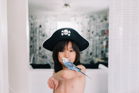Young boy poses with his pet bird